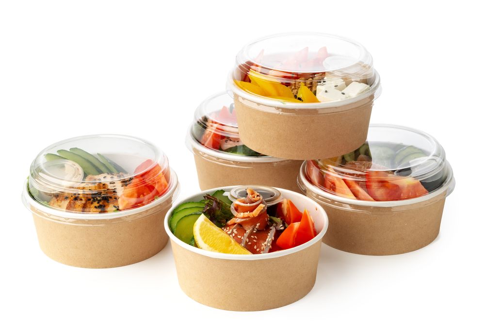 Kraft paper bowls with clear lids filled with salads